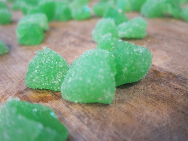 Green gumdrops are cut to use as the pumpkin stem