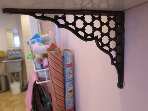 Antique iron shelf brackets add old-world charm to a new craft room