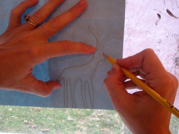 Using a window as a lightbox, transfer the child's drawing to the card paper by tracing.