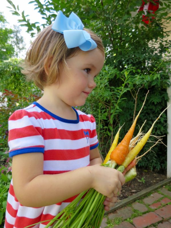 Diana holding homegrown carrots